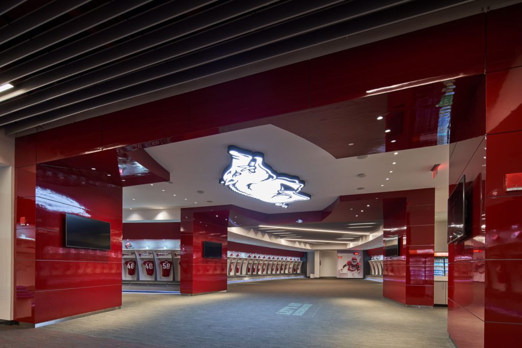 Arkansas Razorbacks new football gameday lockers in curved room designed to resemble football with powerful subtle branding elements