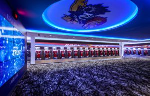Kansas Jayhawks new football training and gameday locker room featuring custom lockers by Shield, active ventilation, digital nameplates, integrated technology and custom branded engraving