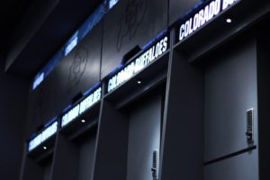 Colorado Buffaloes Basketball lockers detail view of backlit acrylic brand elements, acrylic solid surface construction, and solid wood overhead storage door